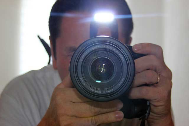 man taking flash photo.