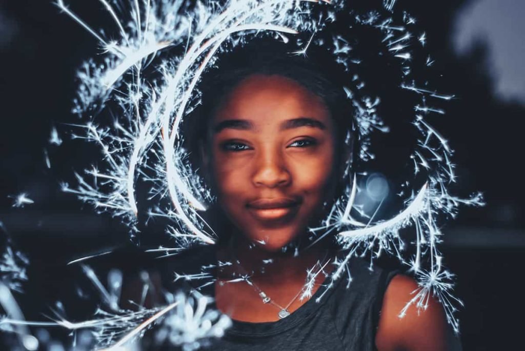 portrait of black girl surrounded by streaks of light in the dark