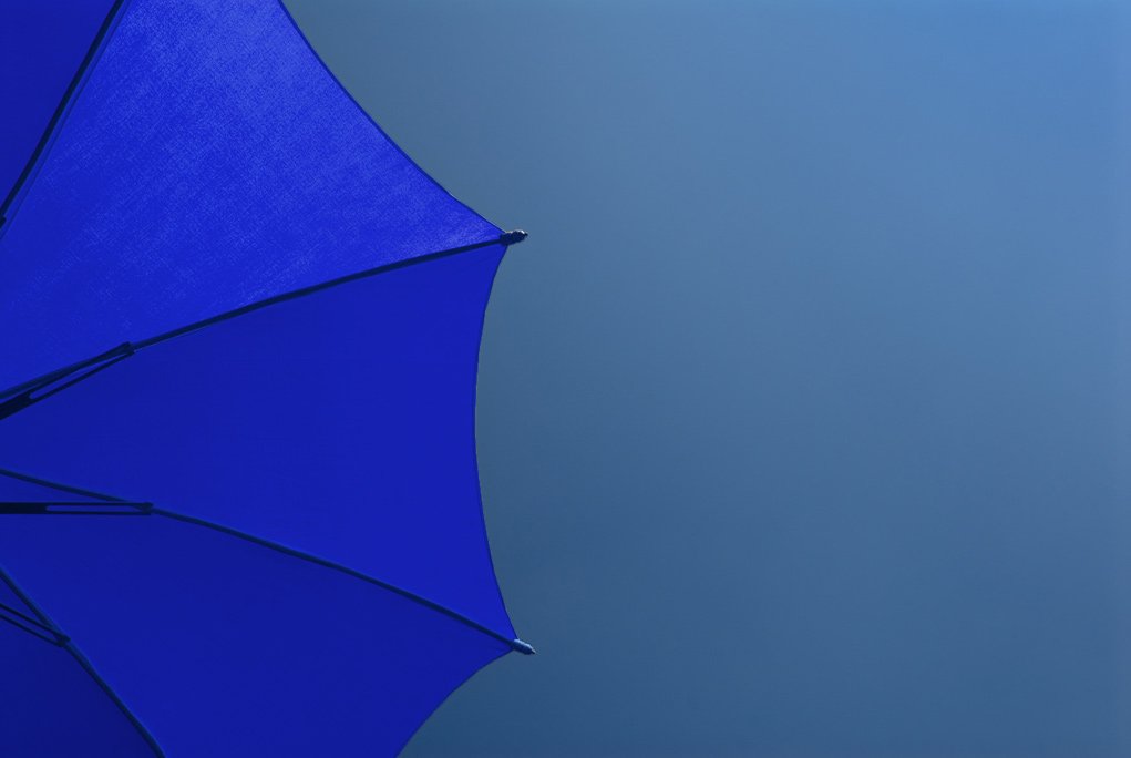 Blue parasol against a blue sky for understanding color in photography series.