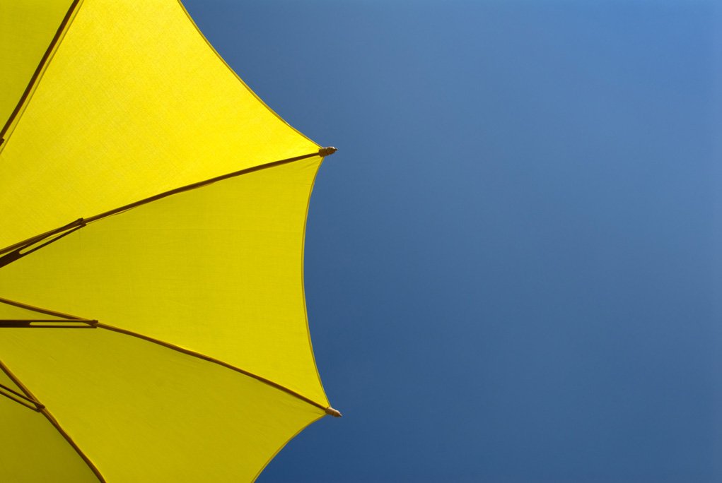 Yellow parasol against a blue sky for understanding color in photography series.