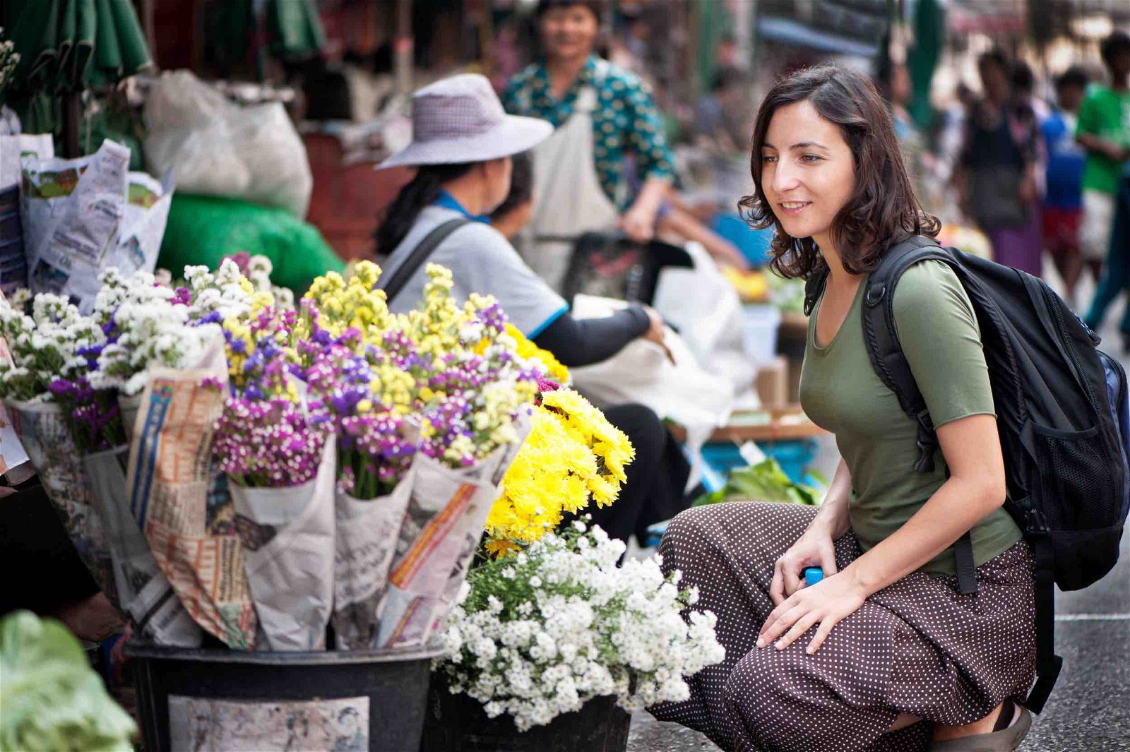 Young woman buying flowers at a street market.