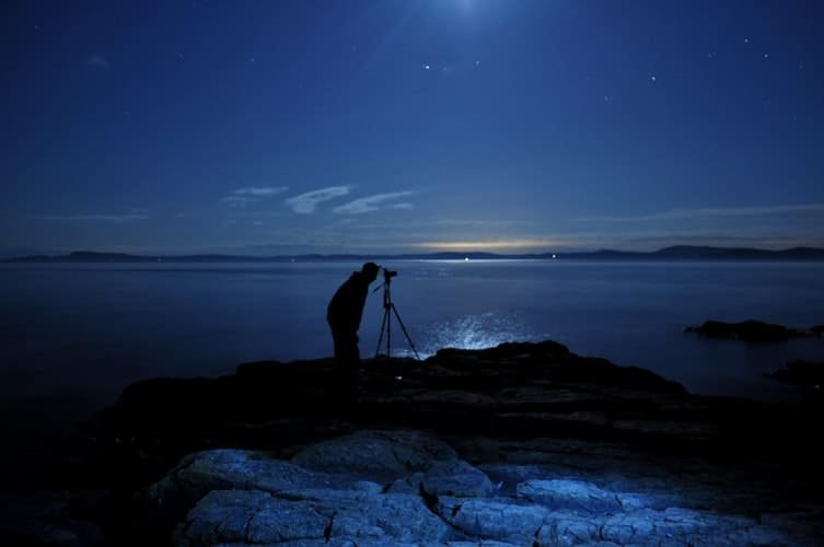 For night photography, a tripod, as seen in this photograph, is a must for clear images.