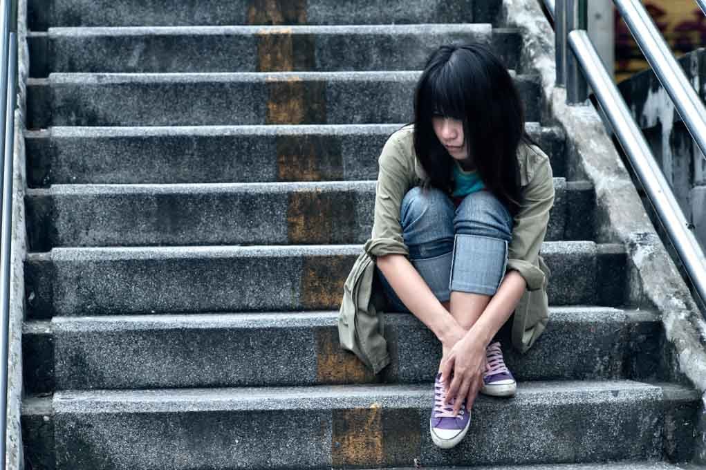 woman sitting on steps outdoors.