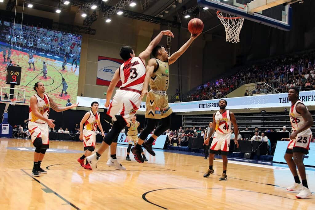 A telephoto zoom lens with a wide aperture can help you both get in close and let in enough light, as seen in this image of an indoor basketball game.