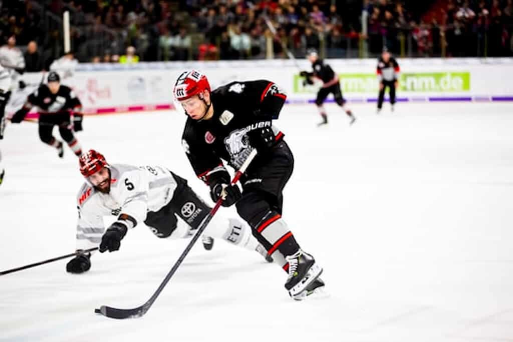 To get those great sports images, you need a fast lens to freeze the action, like that seen in this ice hockey game. 