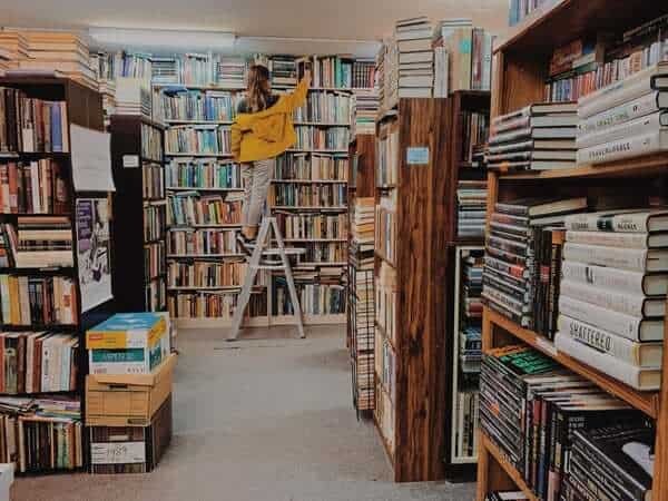 For interior photography, you want the lines of the space to lead the viewer’s eye to the main focus, as seen in this image of bookshelves and a person taking a book from the highest shelf.