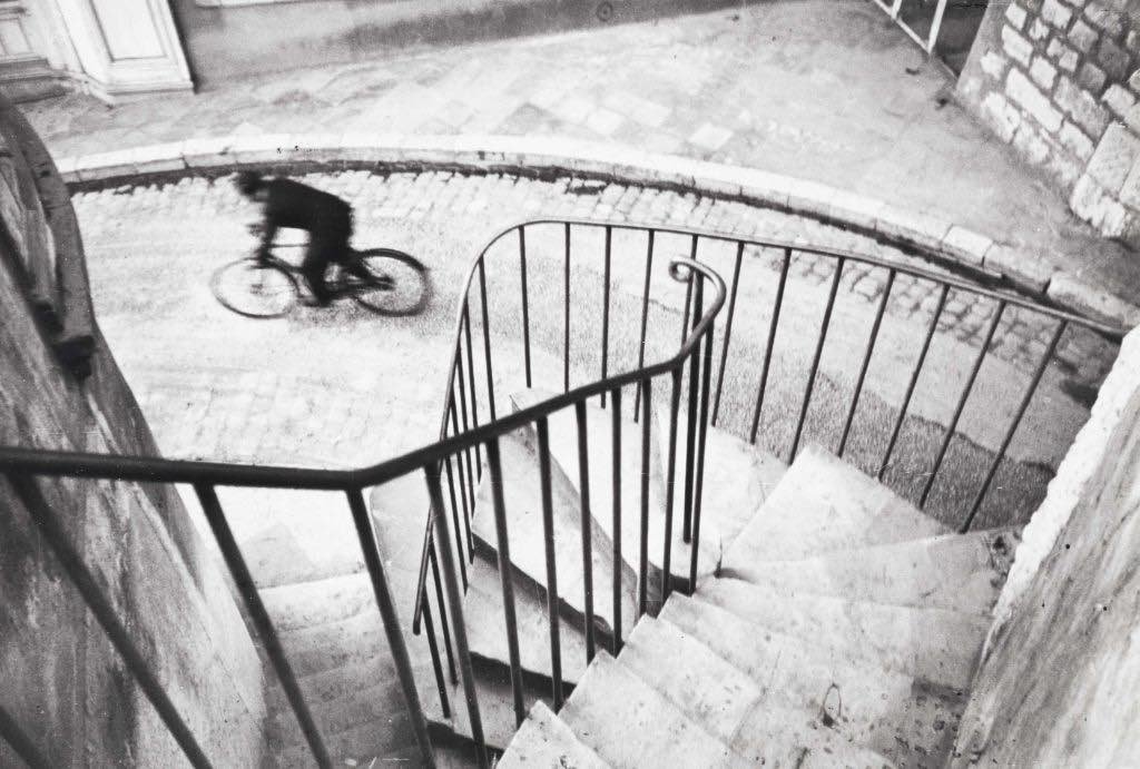 cyclist passing through the street - by henri cartier-bresson