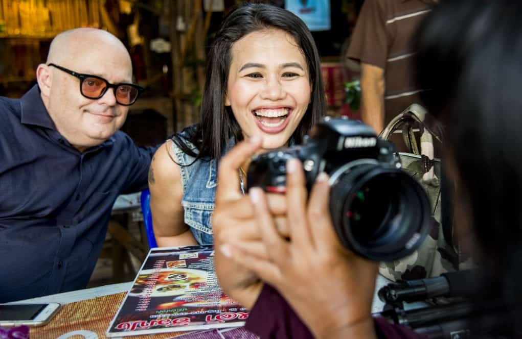 People looking at a photo on a camera.