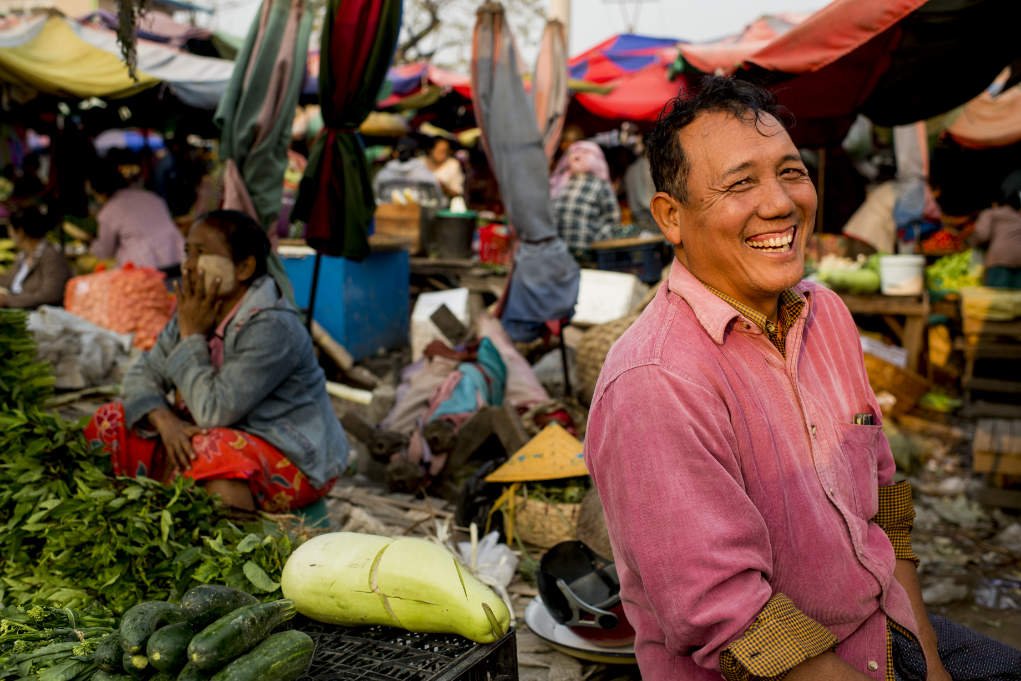 man selling vegetables in a market.