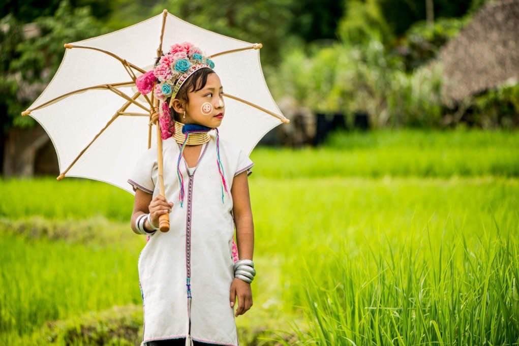 Kayan girl with a parasol and naturally blurred background.