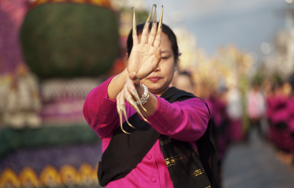 Thai dancer in a street parade isolated with a shallow depth of field.