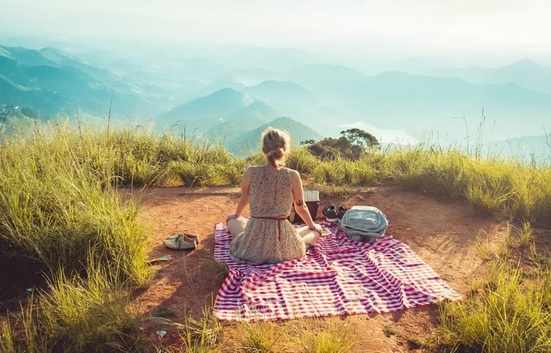 Lifestyle photography captures those authentic moments that tell a story about your subject, such as this picture of a woman having a picnic in a beautiful outdoor setting.