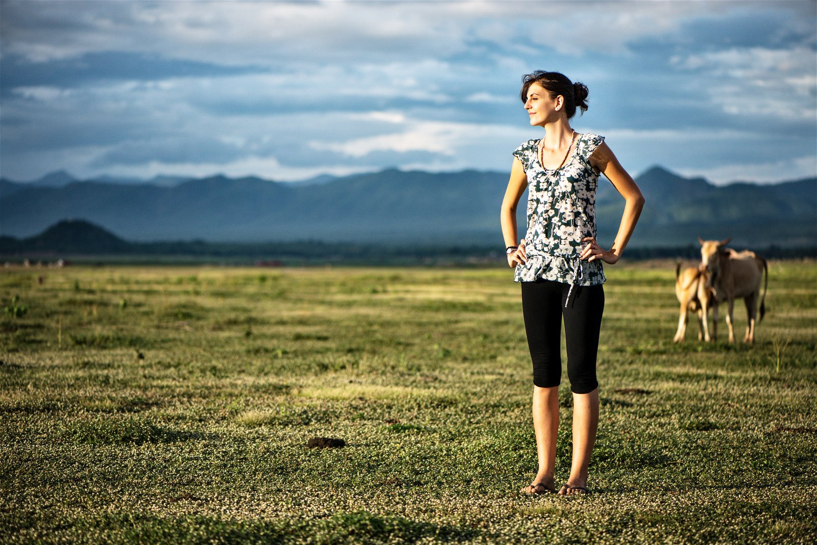 Young woman standing in an open field.