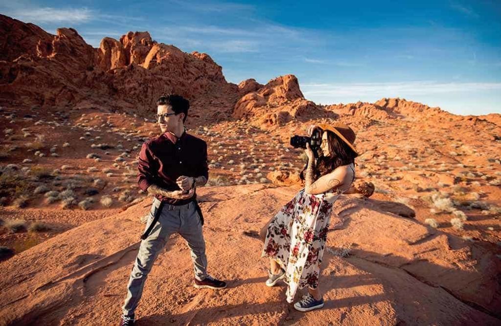 Fashion photographer having a photoshoot with a male model in the desert