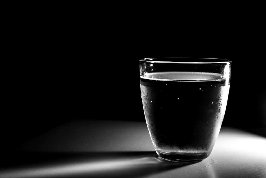 glass of water in black and white with low light.