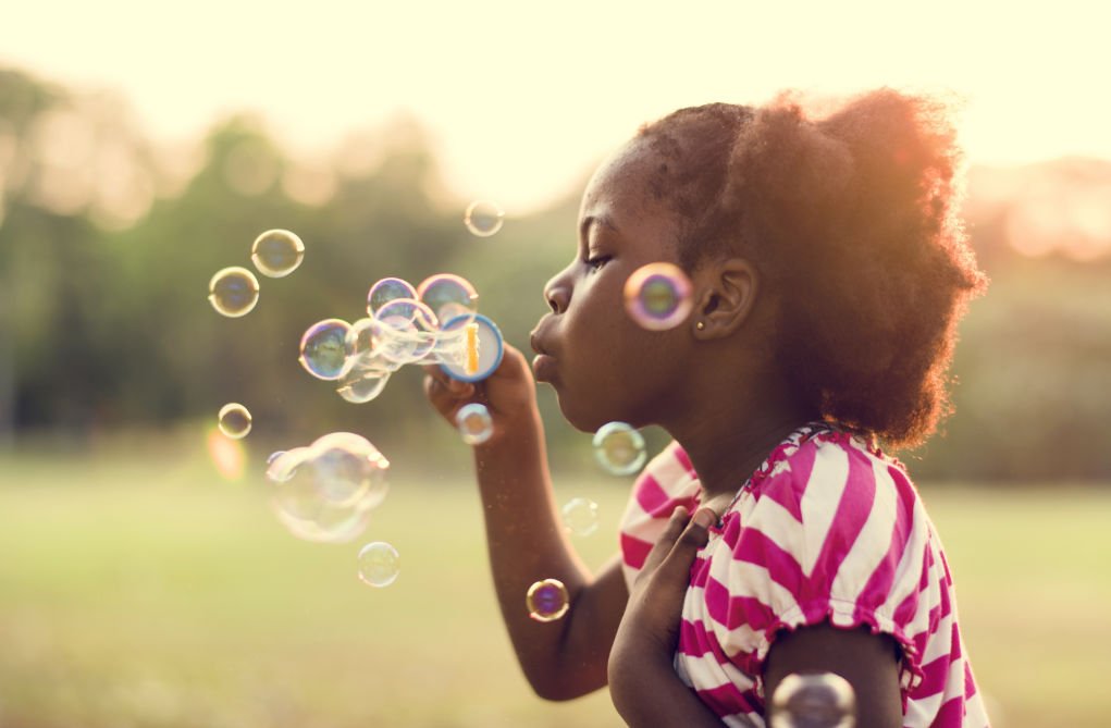 girl blowing bubbles.