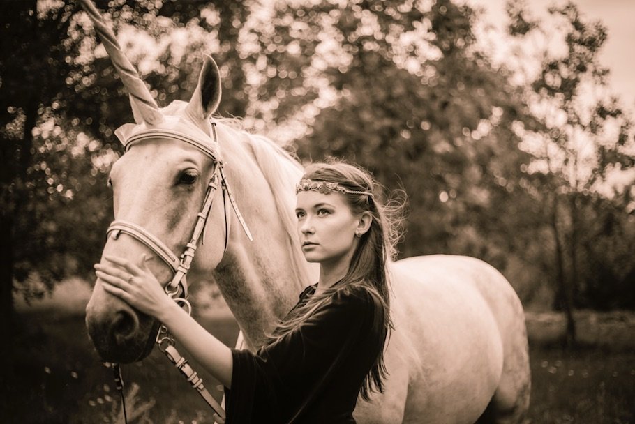 warm toned portrait of a young woman with a horse outdoors.