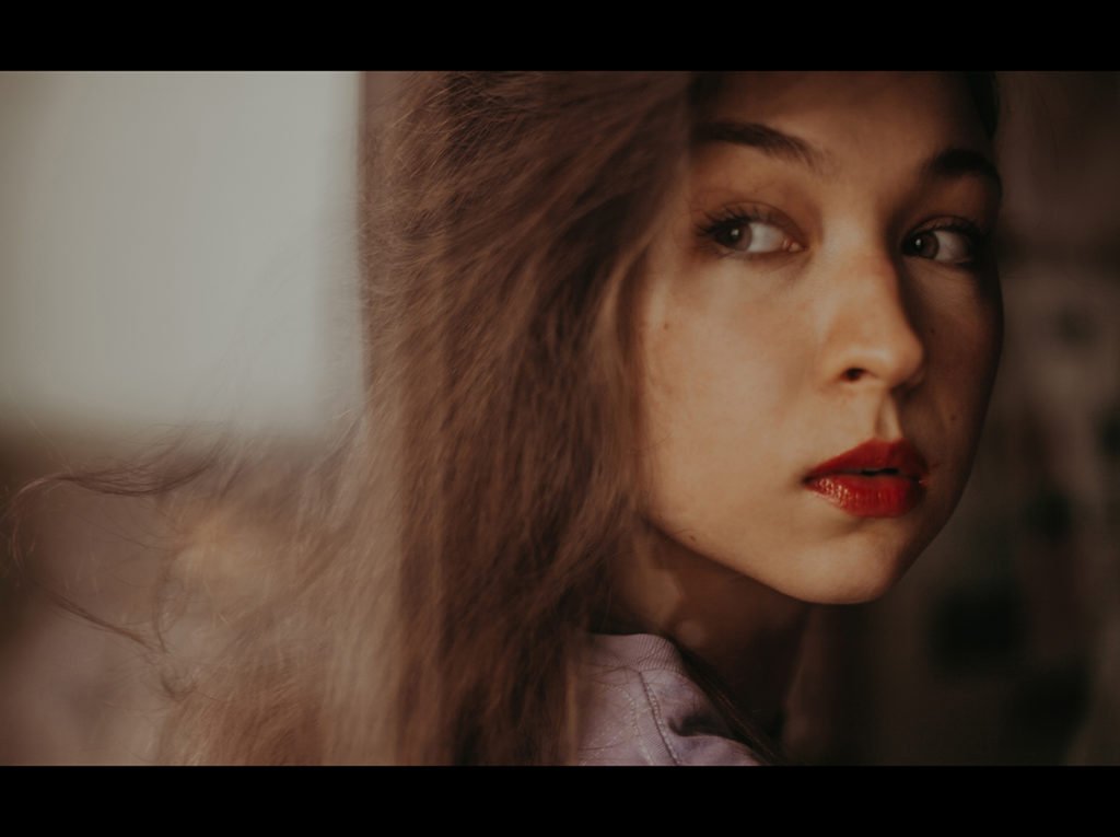 Cinematic portrait of a girl looking over her shoulder.
