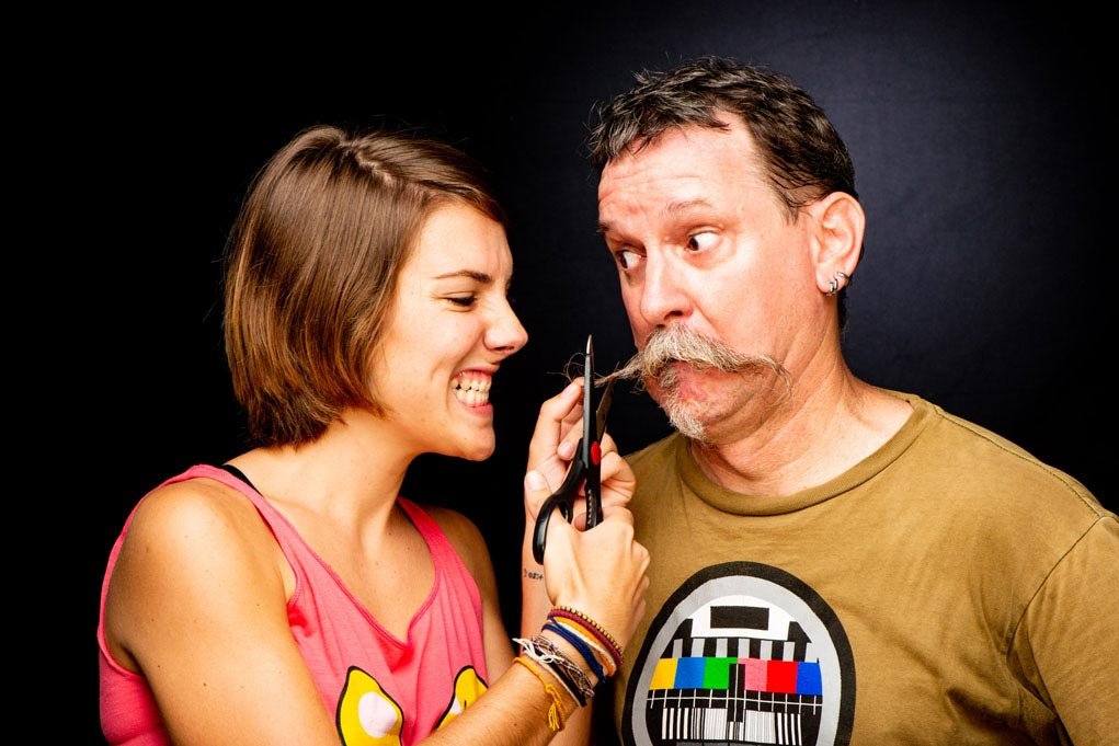 Woman appearing to cut a man's moustache for how to unblur an image.
