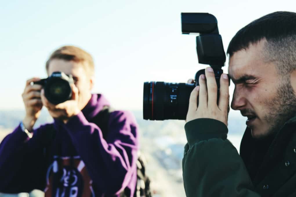 two men using dslr cameras for smartphone camera vs dslr.