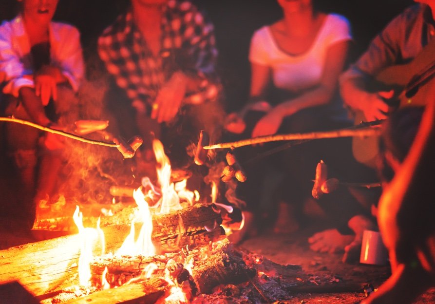 people around a campfire by night.