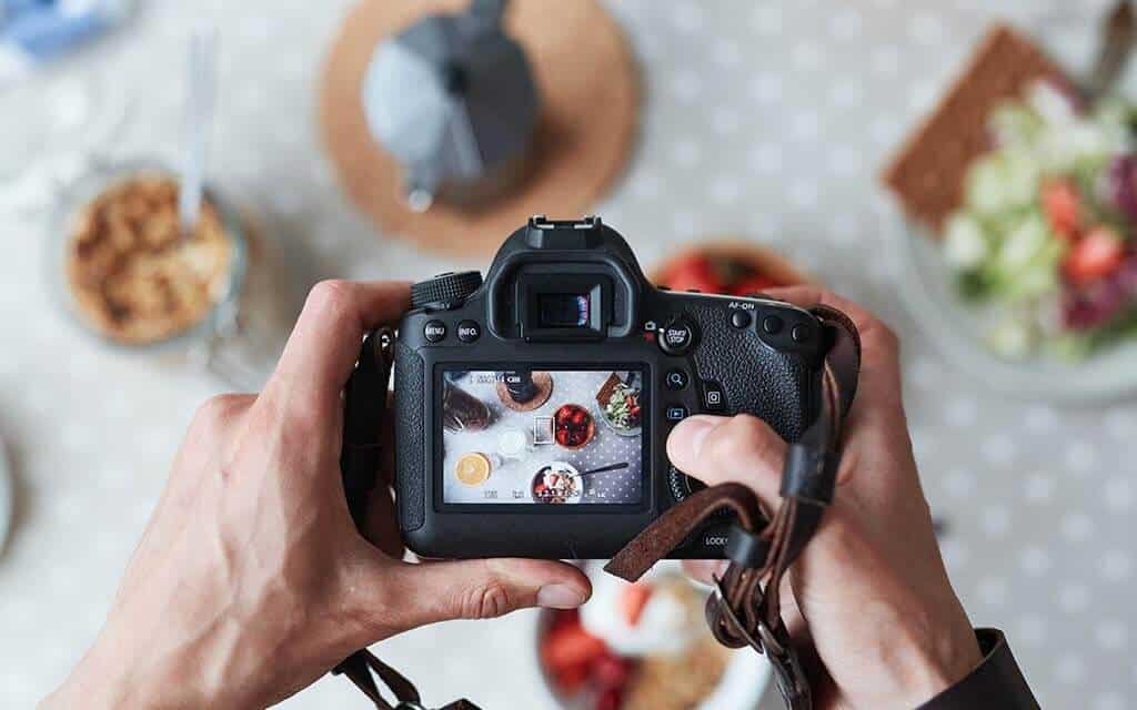 person taking photos of food with a DSLR.