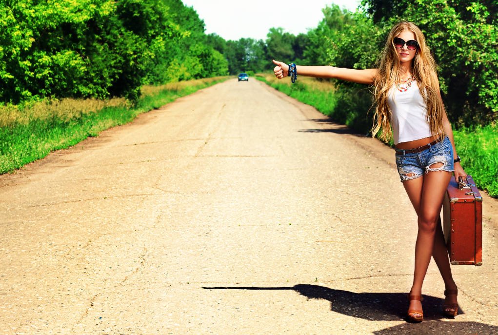 woman hitching a ride with a case.