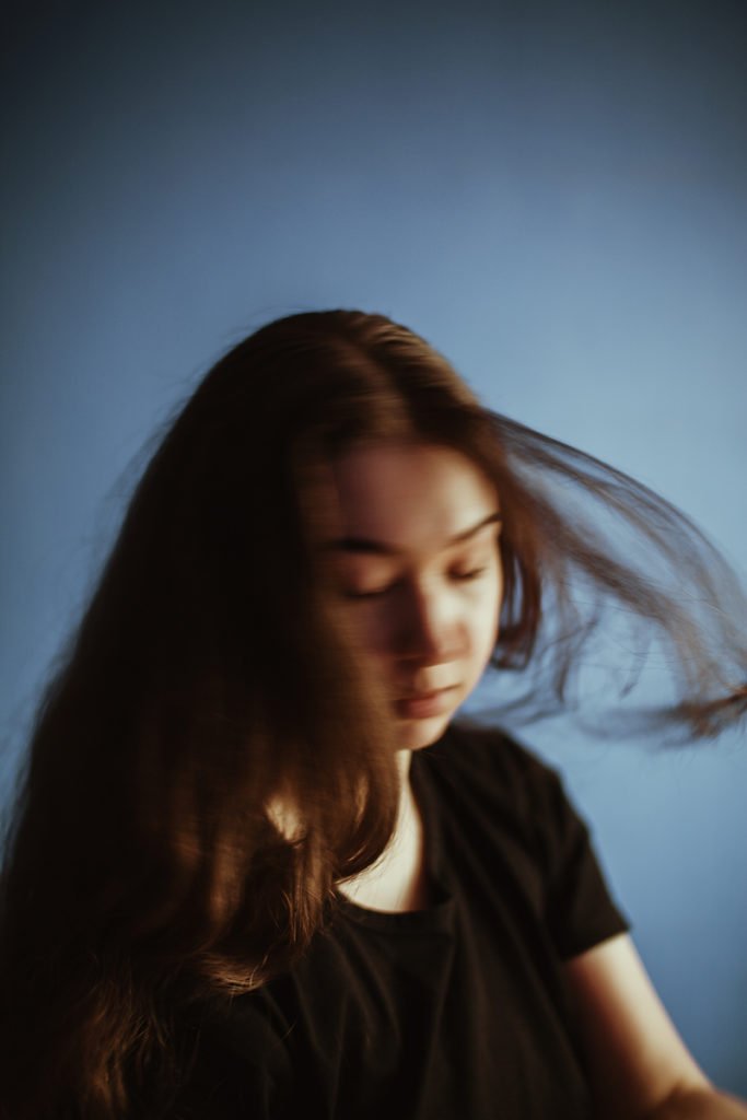 Self-portrait featuring motion blur. The model is turning around and her face isn’t clear.