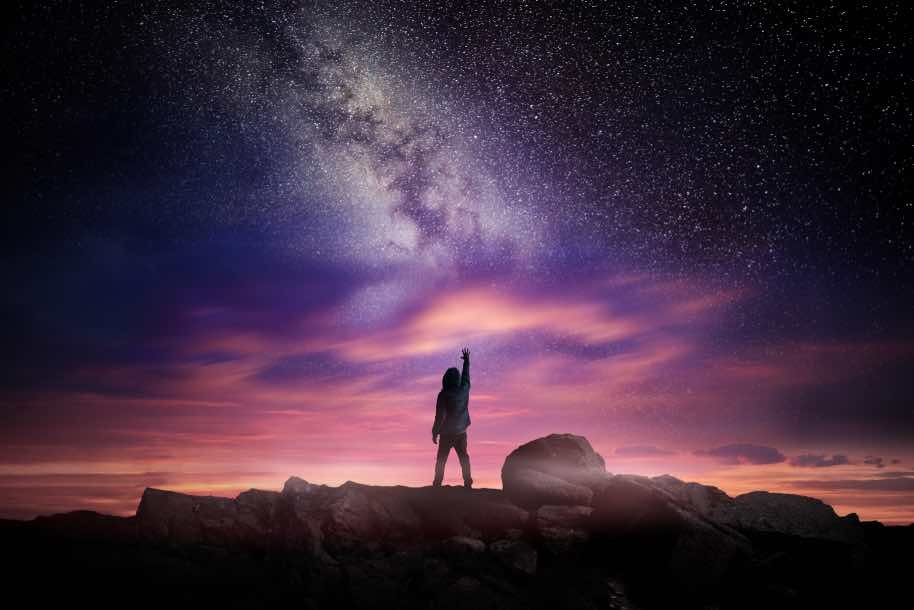 man standing under a starry night sky.