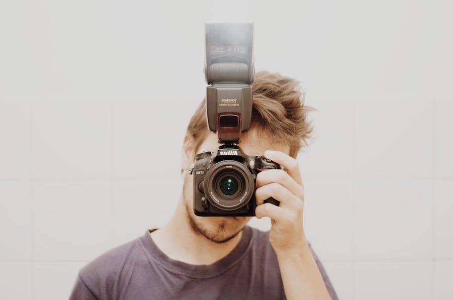 man taking photo from nikon camera using external flash