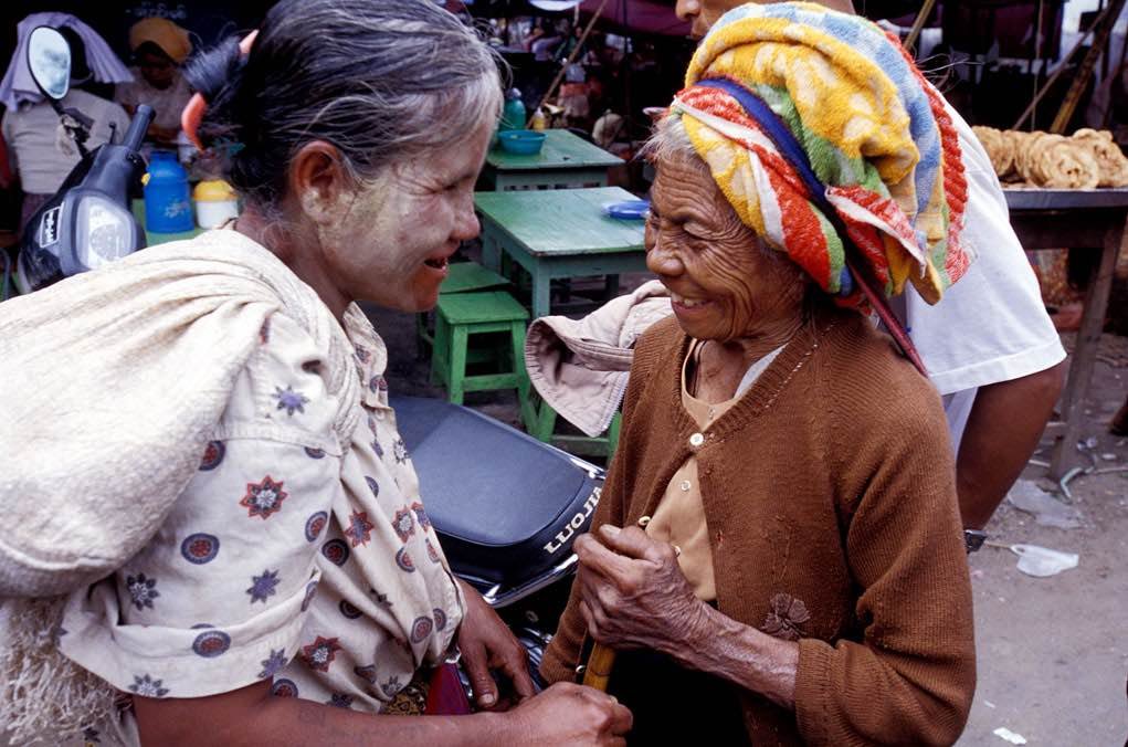 photograph of two women meeting in a street market
