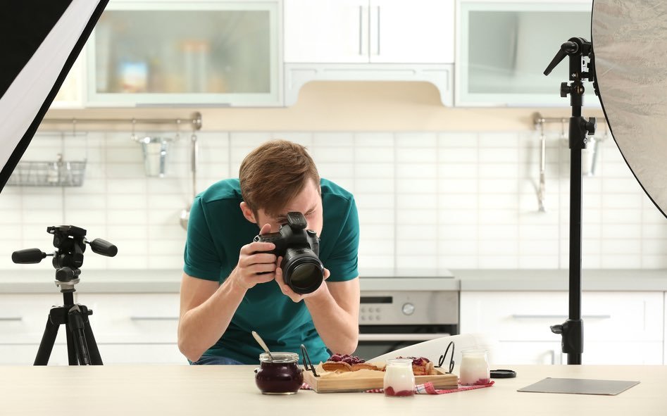photographer photographing food with lighting in a kitchen.