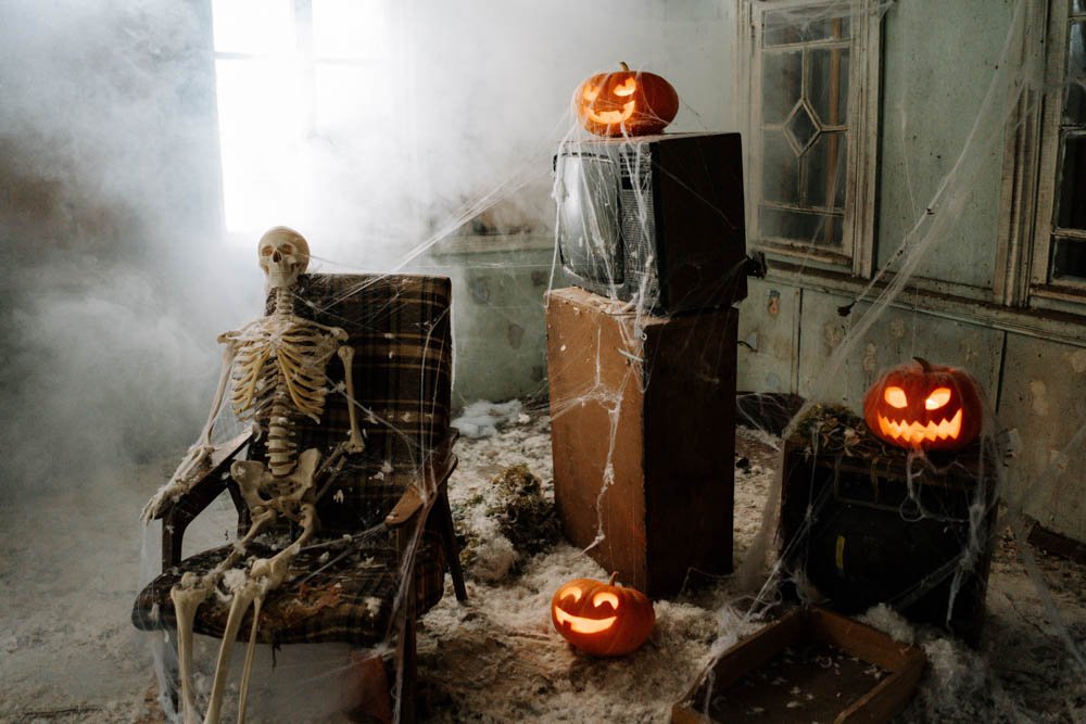 Skeleton and jack o lanterns placed creatively in a room.