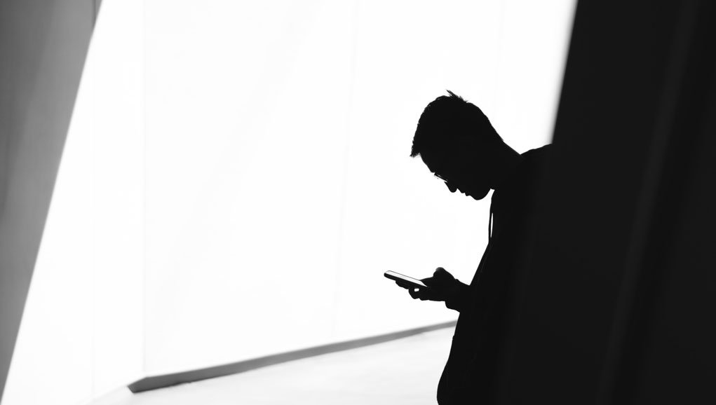 man using a phone, high contrast image.