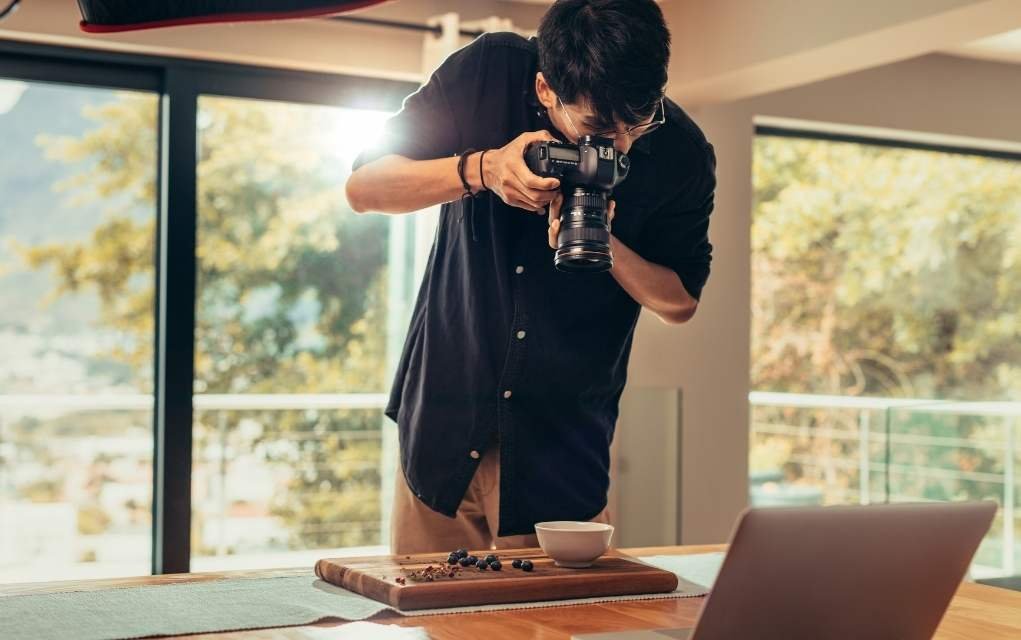 person taking photo of food with a zoom lens.
