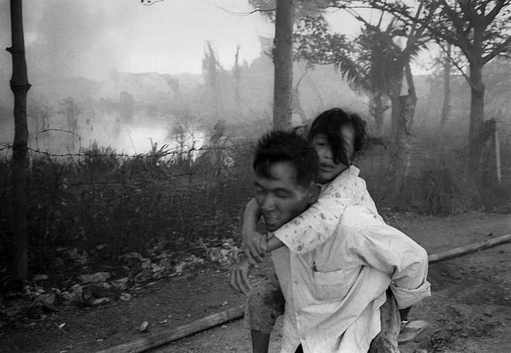 Man and child running from battle in Saigon - Image by Jones Griffiths.