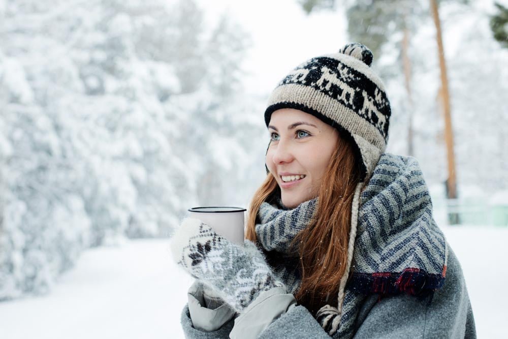 Model Staying warm with hot drinks on a photoshoot.