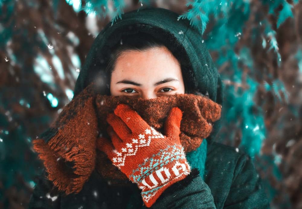 Woman looking towards camera wearing winter clothes.