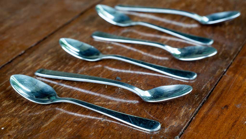 acceptably sharp focus - spoons on a table in a straight line.