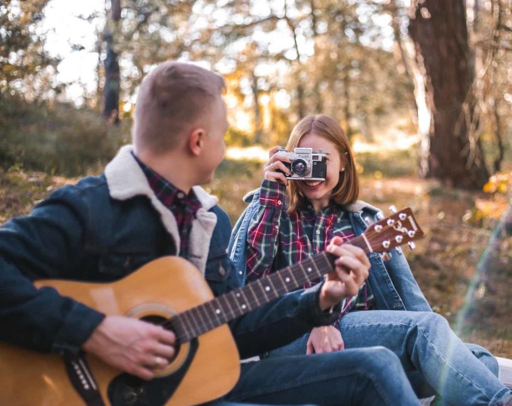 photographer taking pictures of a musician outdoors.
