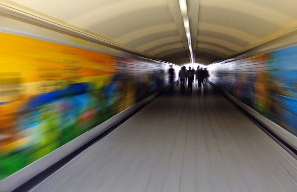 people walking through a tunnel.