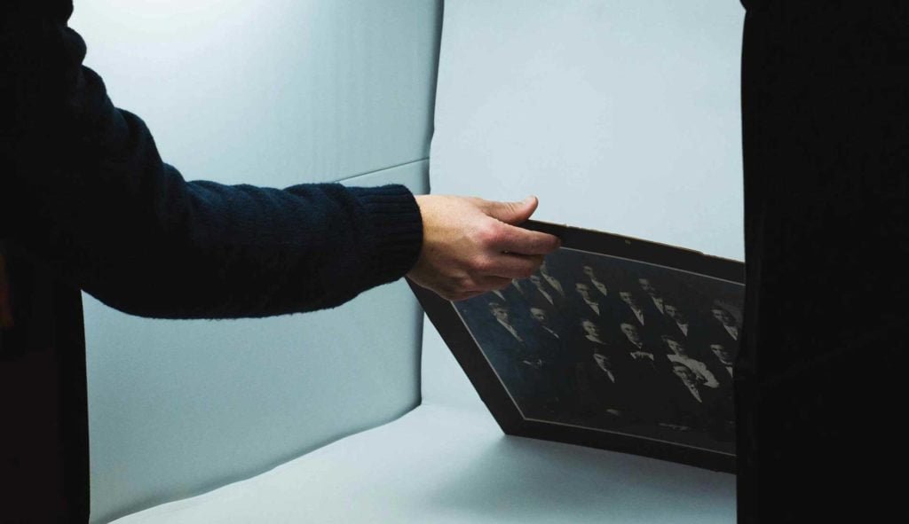 person holding a photo inside a light box.